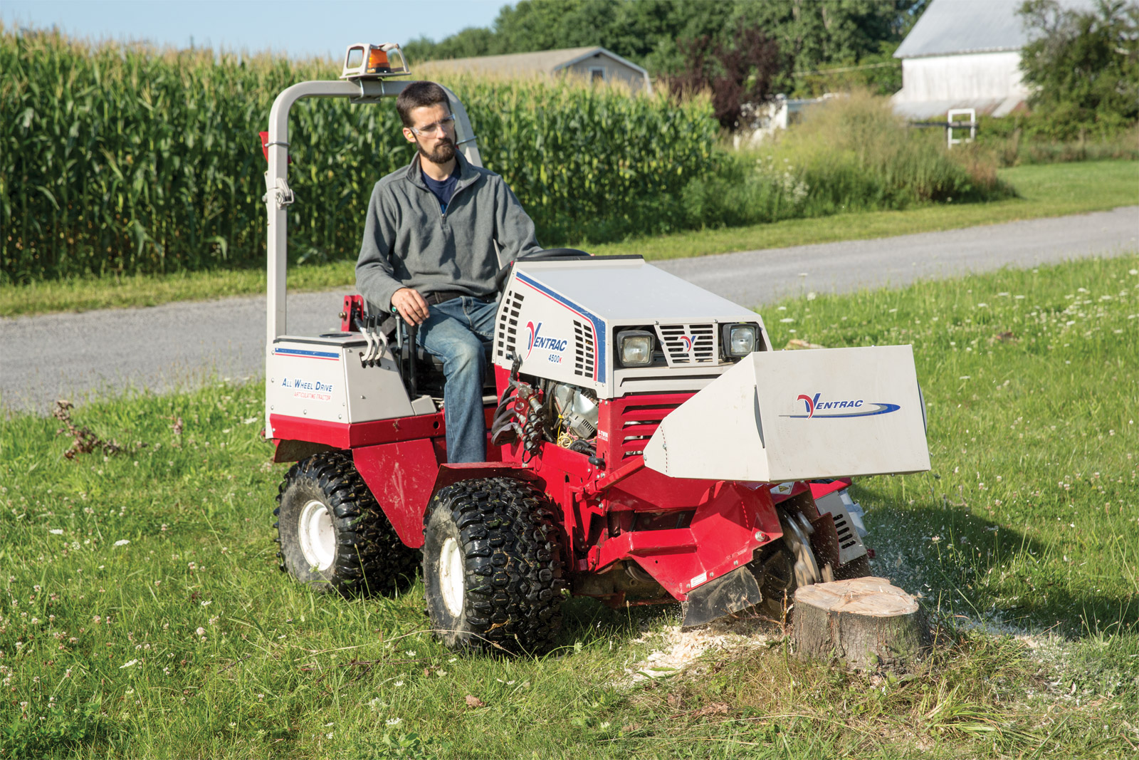A compact tractor mowing farm land